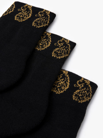 Close-up of gold LUKE lion head embroidery on black Zale ankle socks