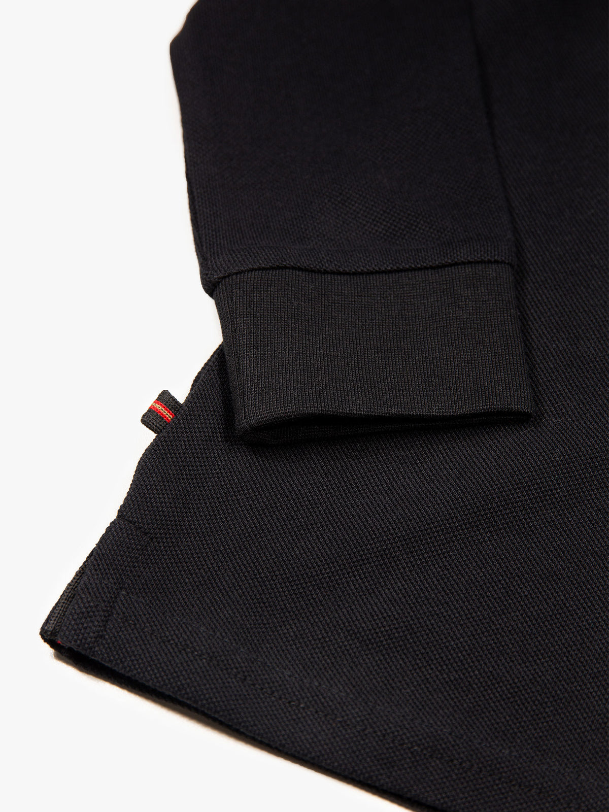 Close-up of rib trims on black Williams 1000 junior long sleeved polo shirt
