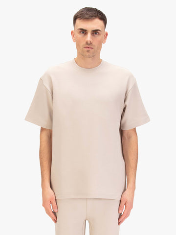 Men's relaxed-fit beige t-shirt with crew neck and short sleeves, worn by a model, front view