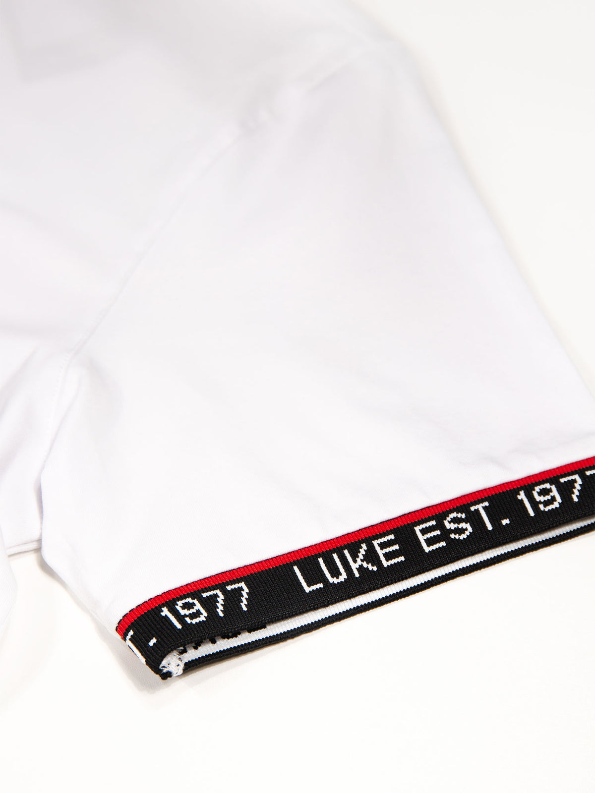 Close-up of rib sleeve cuff with LUKE EST. 1977 text on white San Diego t-shirt