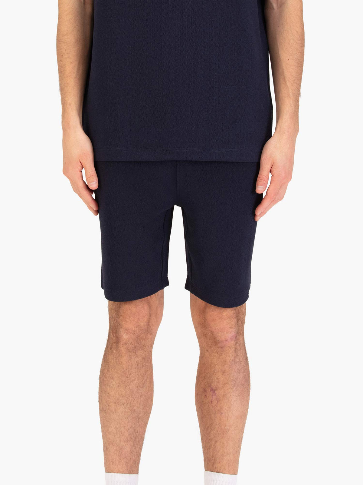 Men's navy shorts with drawstring waistband, worn by a model, front view