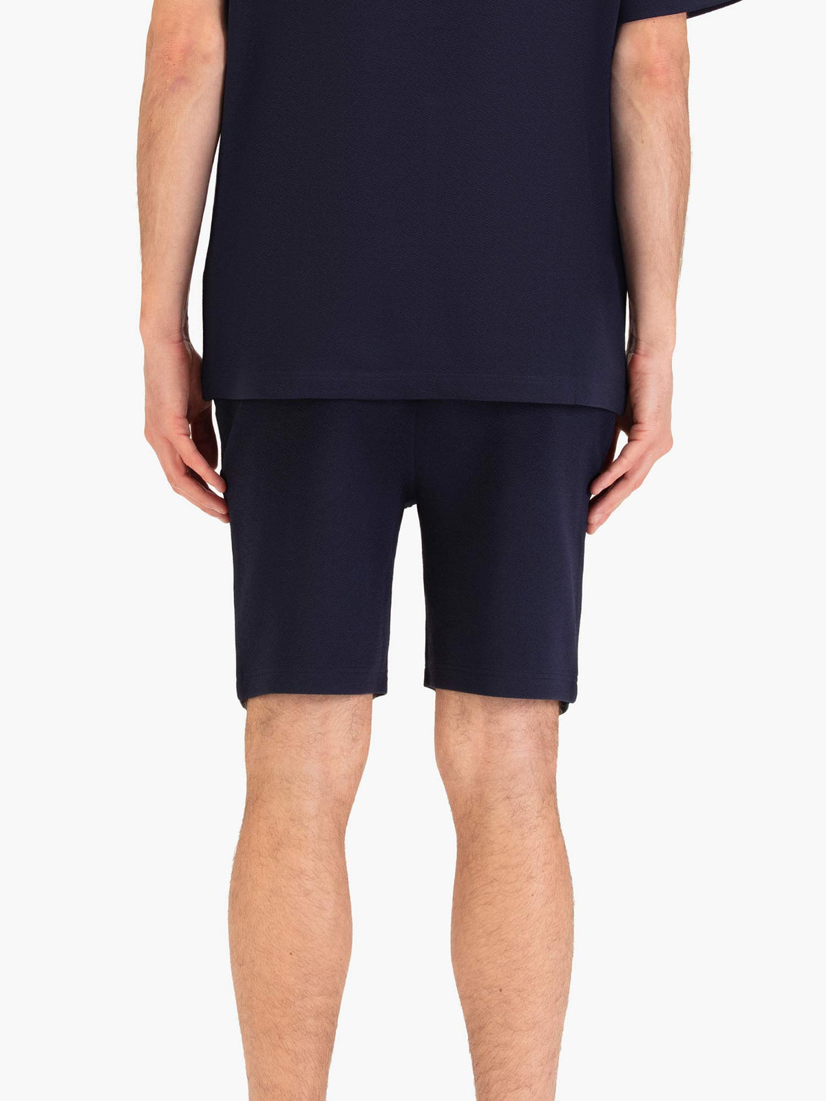 Men's navy shorts with drawstring waistband, worn by a model, back view