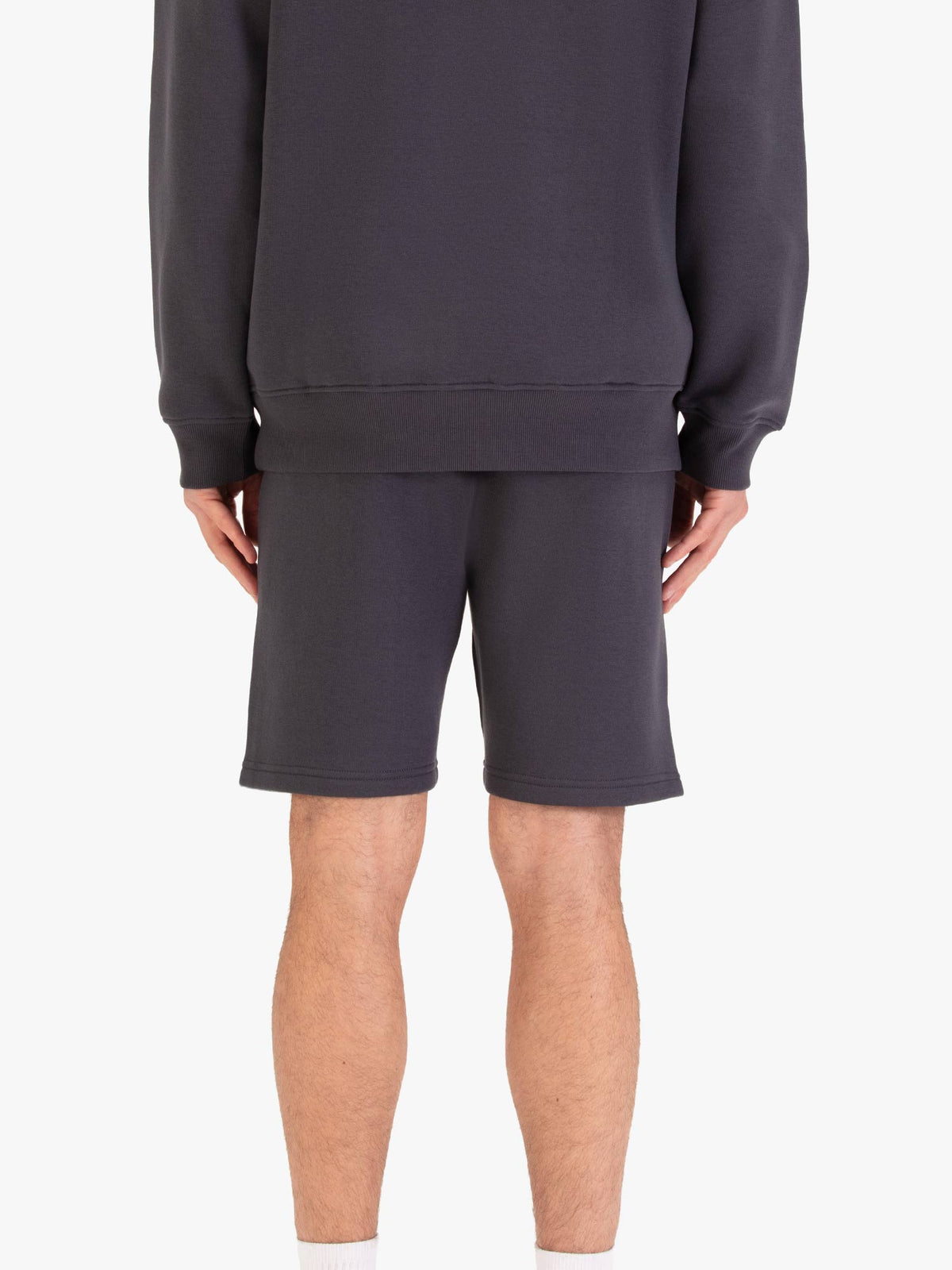 Men's grey shorts with drawstring waistband, worn by a model, back view