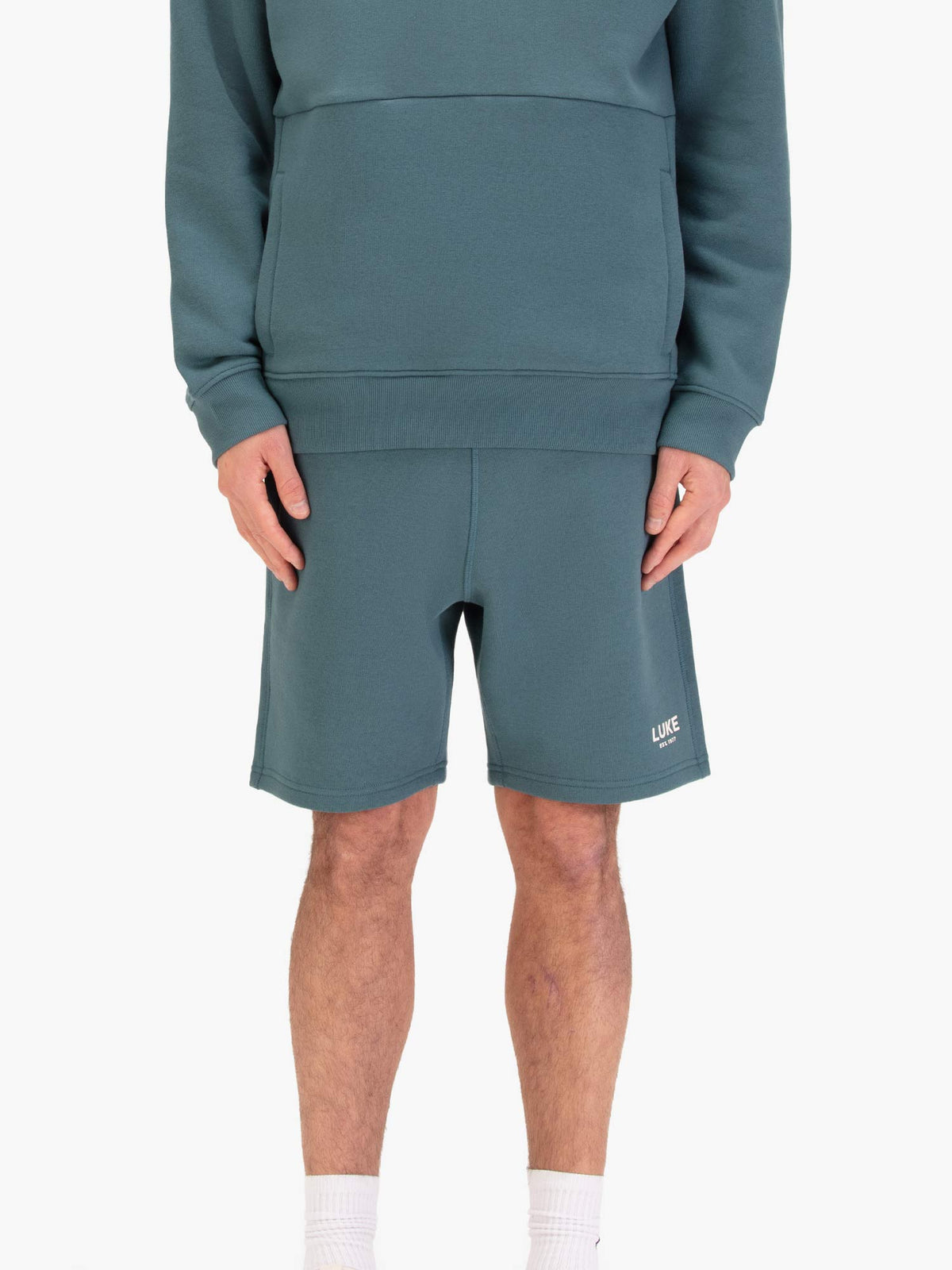 Men's blue shorts with drawstring waistband, worn by a model, front view