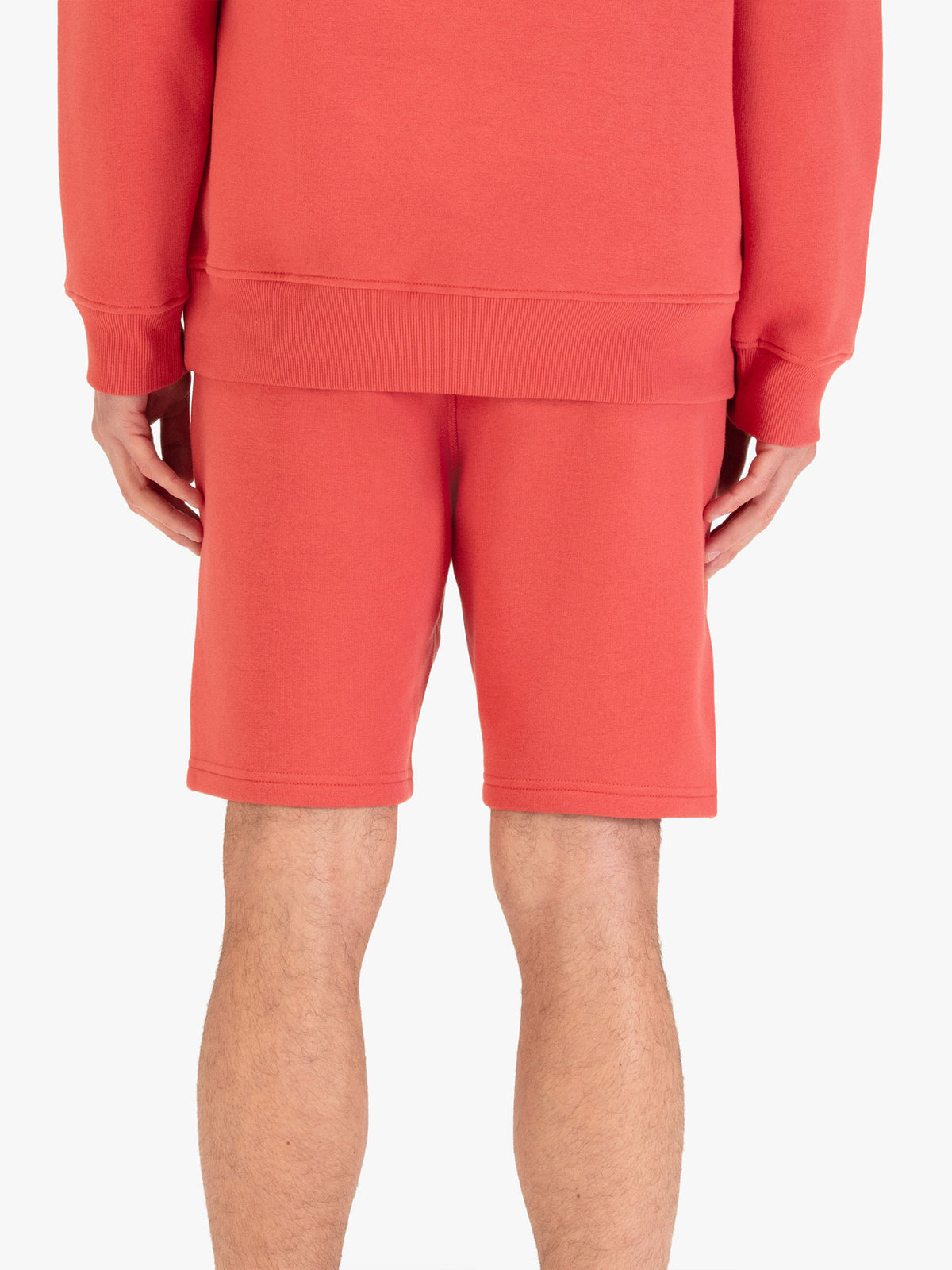 Men's red shorts with drawstring waistband, worn by a model, back view