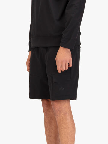 Men's black shorts with drawstring waistband, worn by a model, side view