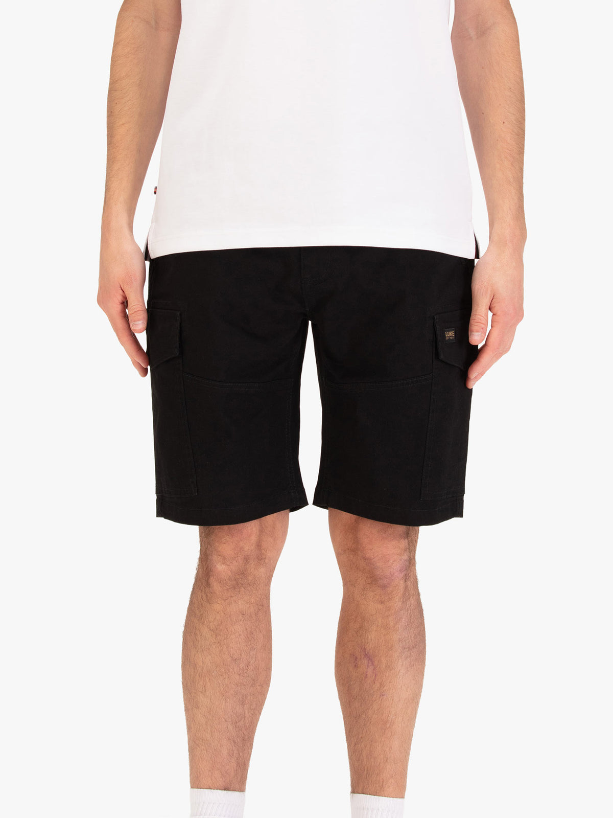 Men's black shorts with drawstring waistband and cargo pockets, worn by a model, front view