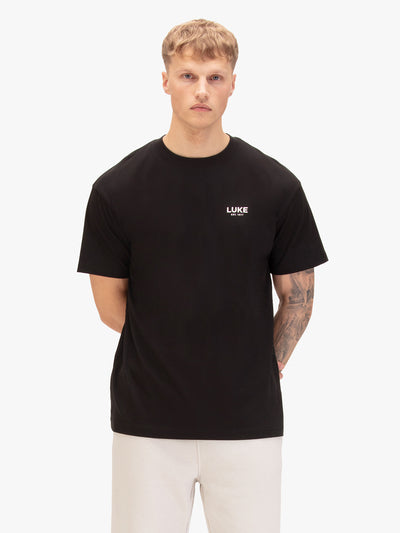 Men's relaxed-fit black t-shirt with crew neck and short sleeves, worn by a model, front view