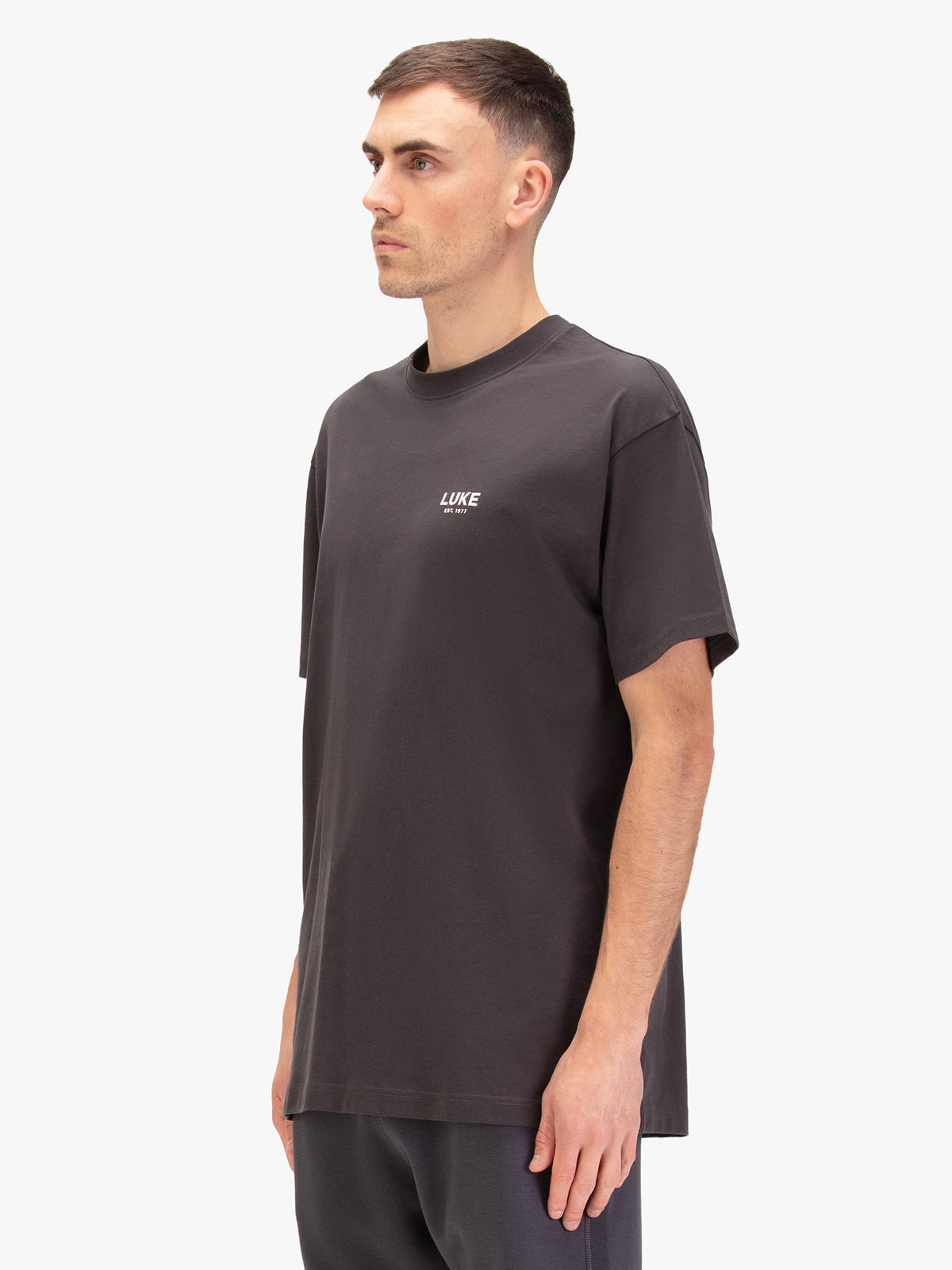 Men's relaxed-fit grey t-shirt with crew neck and short sleeves, worn by a model, side view