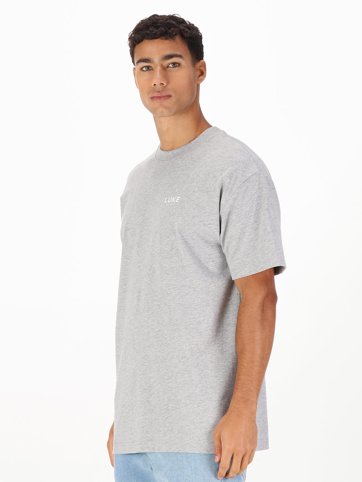 Men's relaxed-fit grey t-shirt with crew neck and short sleeves worn by a model - side view.