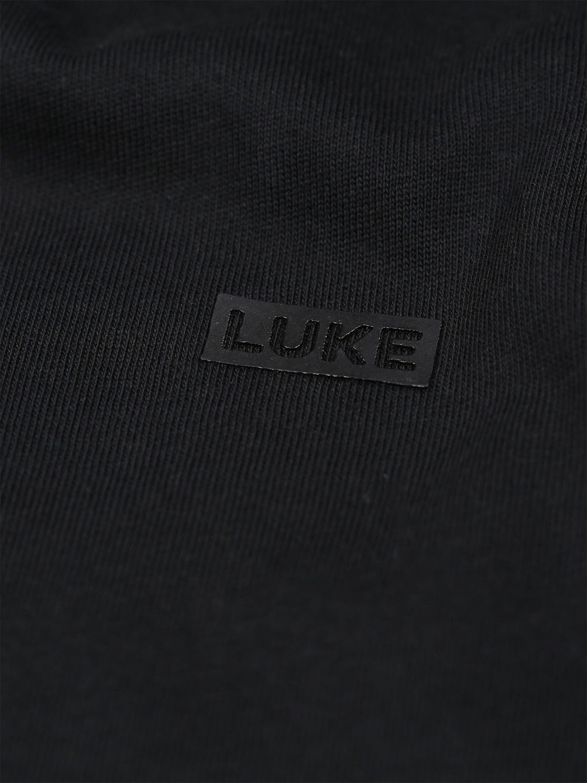 Men's black t-shirt with crew neck and short sleeves worn by a model - side view.