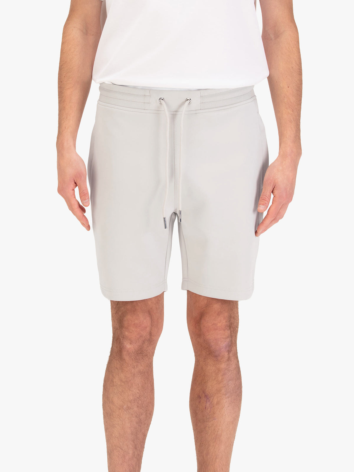 Men's grey shorts with drawstring waistband, worn by a model, front view