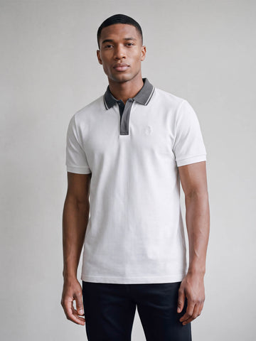 Man wearing white LUKE 1977 Leo pique polo with concrete grey collar, front view