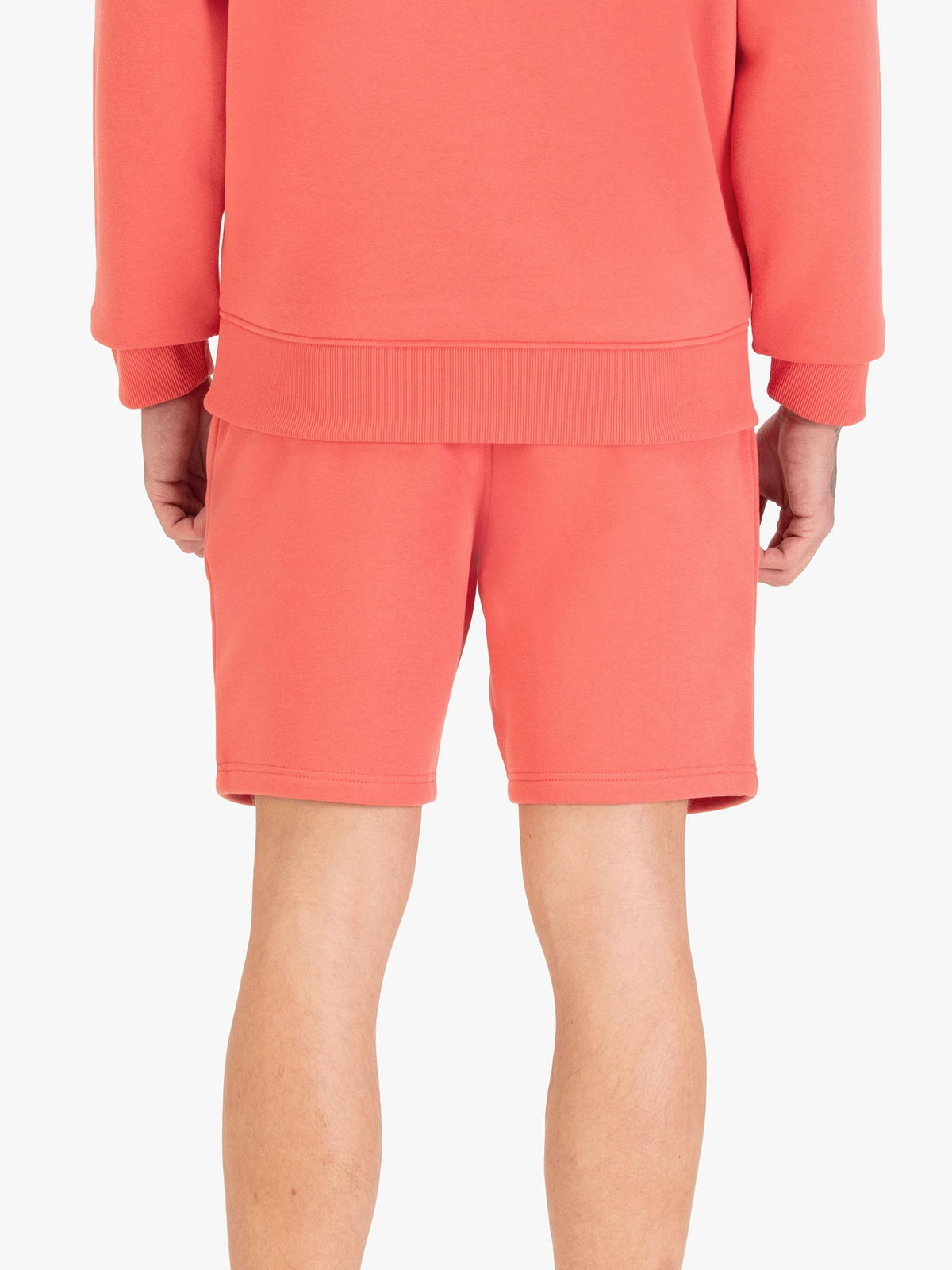Men's red shorts with drawstring waistband, worn by a model, back view