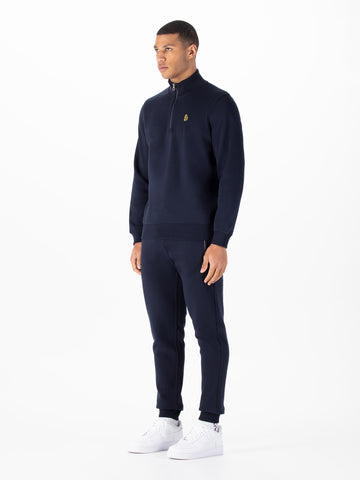 Men's navy tracksuit with quarter zip sweatshirt and matching joggers.