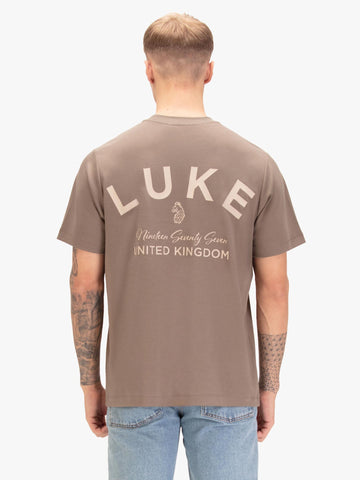 Men's relaxed-fit brown t-shirt with crew neck and short sleeves, worn by a model, back view