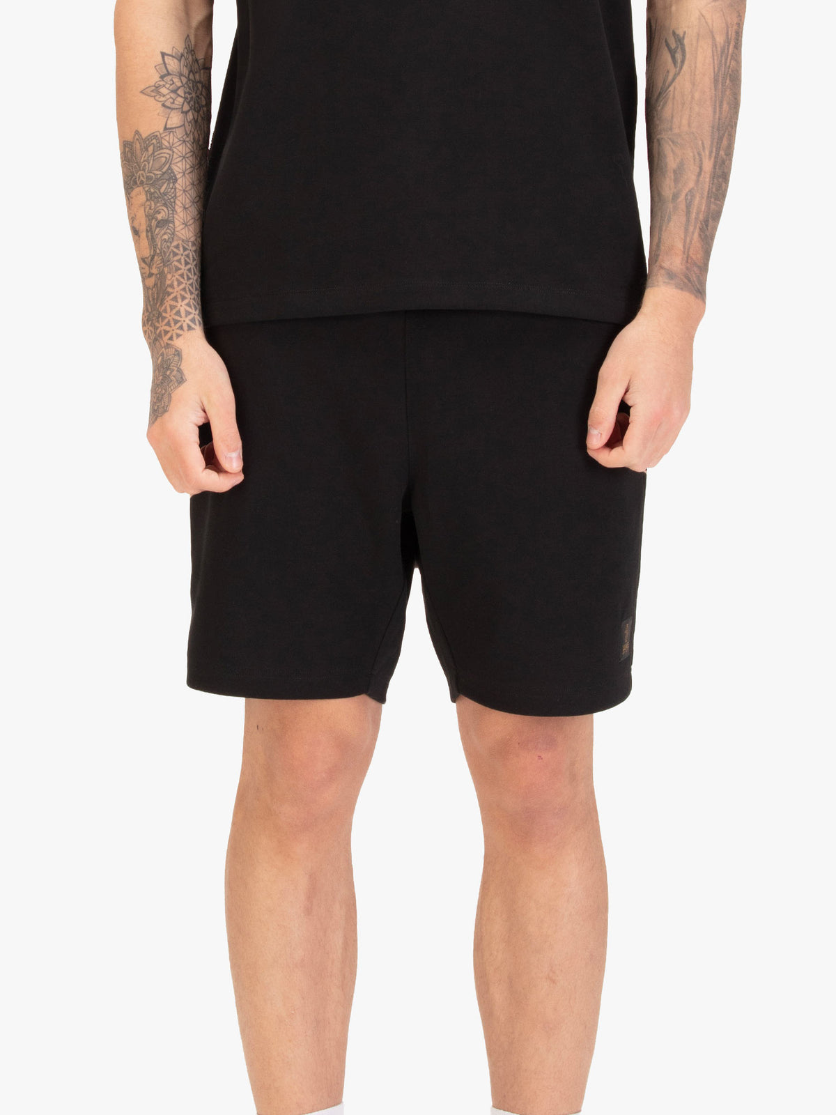 Men's black shorts with drawstring waistband, worn by a model, front view