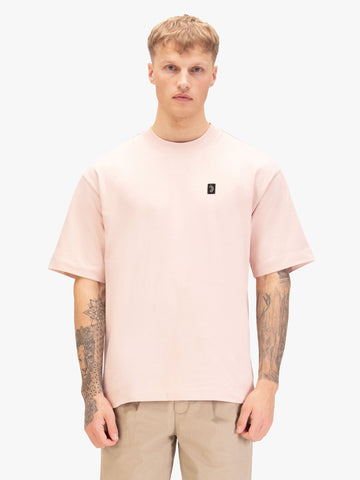 Men's relaxed-fit pink t-shirt with crew neck and short sleeves, worn by a model, front view