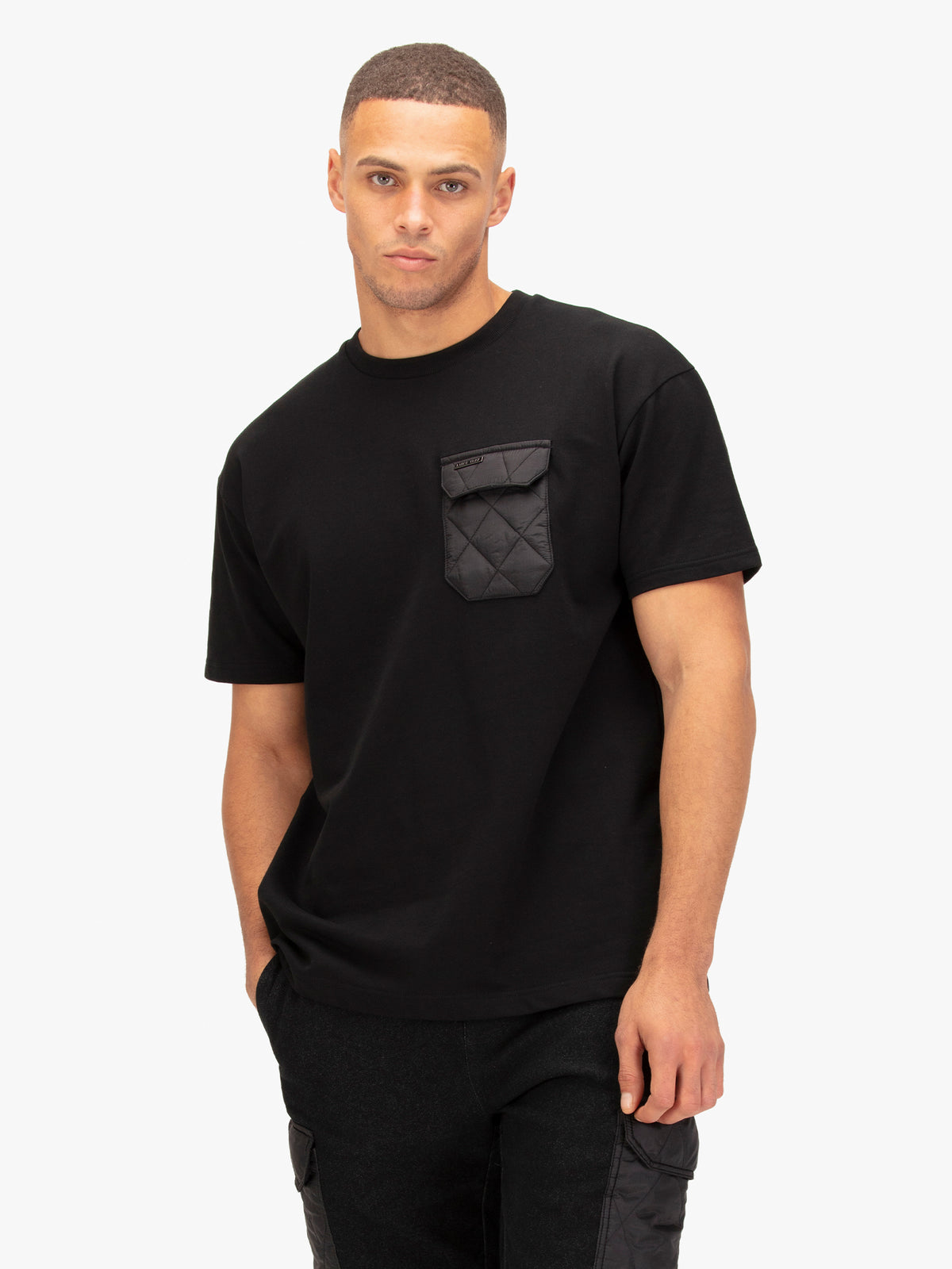 Men's black t-shirt with crew neck and short sleeves worn by a model - side view.
