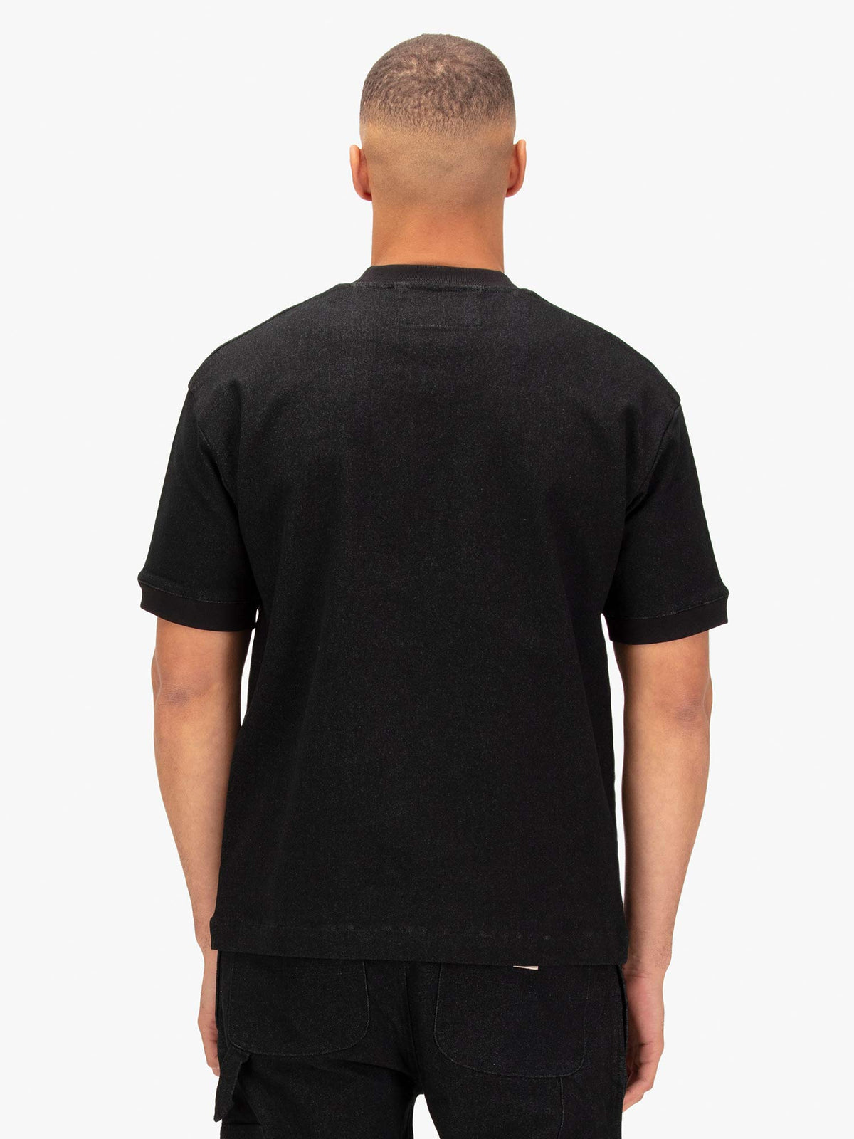 Men's black t-shirt with crew neck and short sleeves worn by a model - back view.