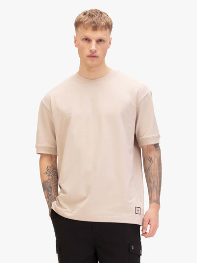 Men's relaxed-fit beige t-shirt with crew neck and short sleeves, worn by a model, front view