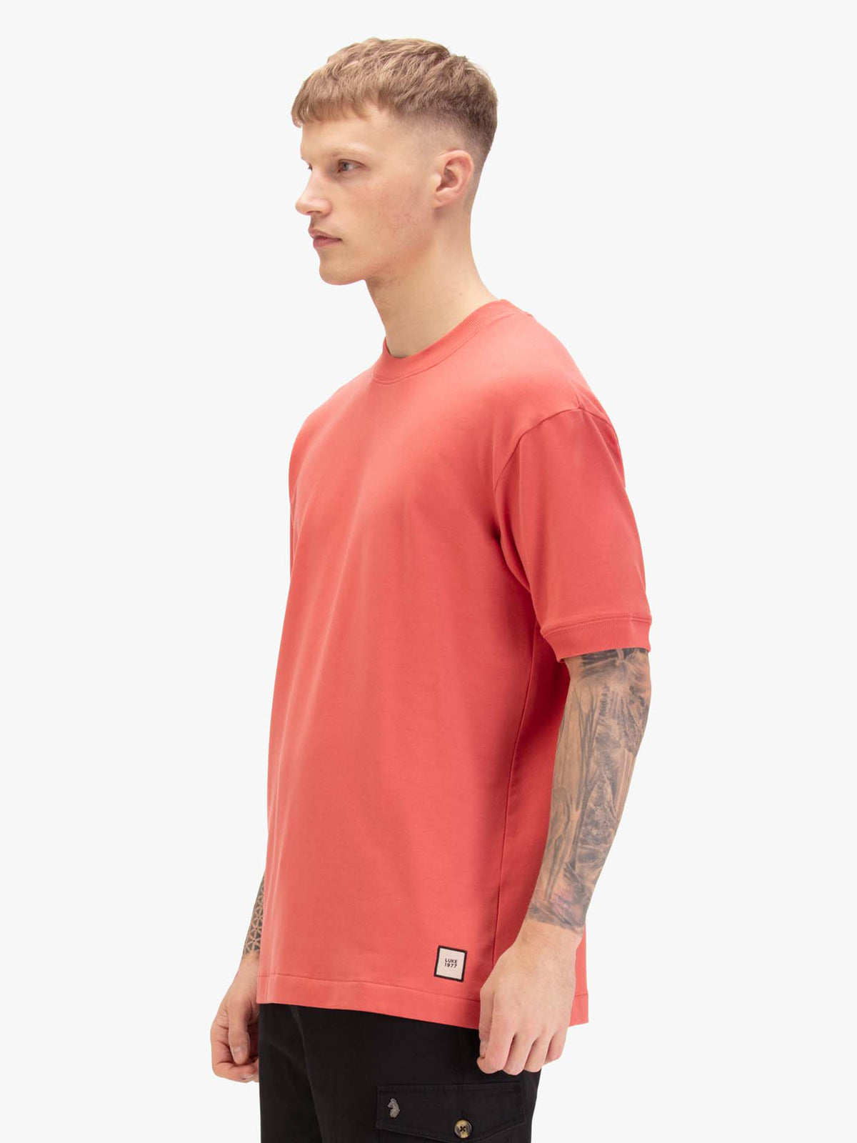 Men's relaxed-fit red t-shirt with crew neck and short sleeves, worn by a model, side view