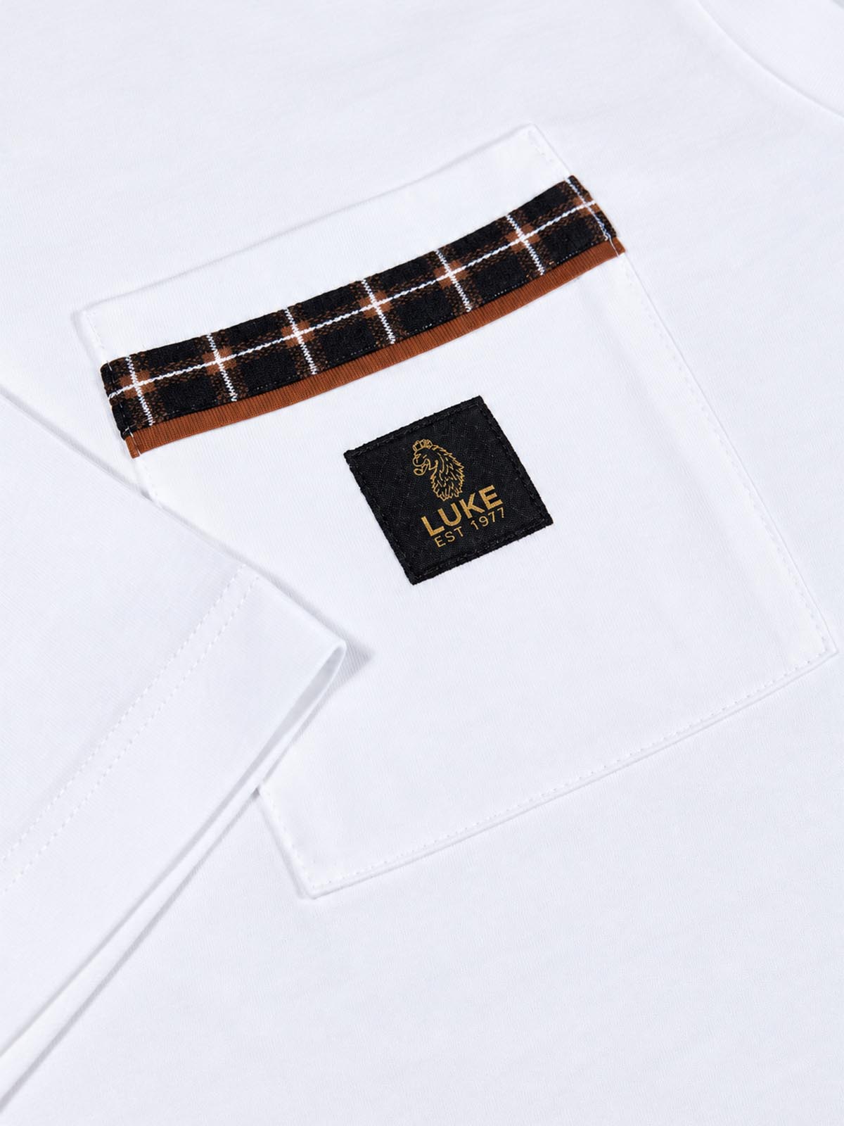 Close-up of chest pocket with contrast check panel and bi-colour woven lion head badge on white Kirk t-shirt