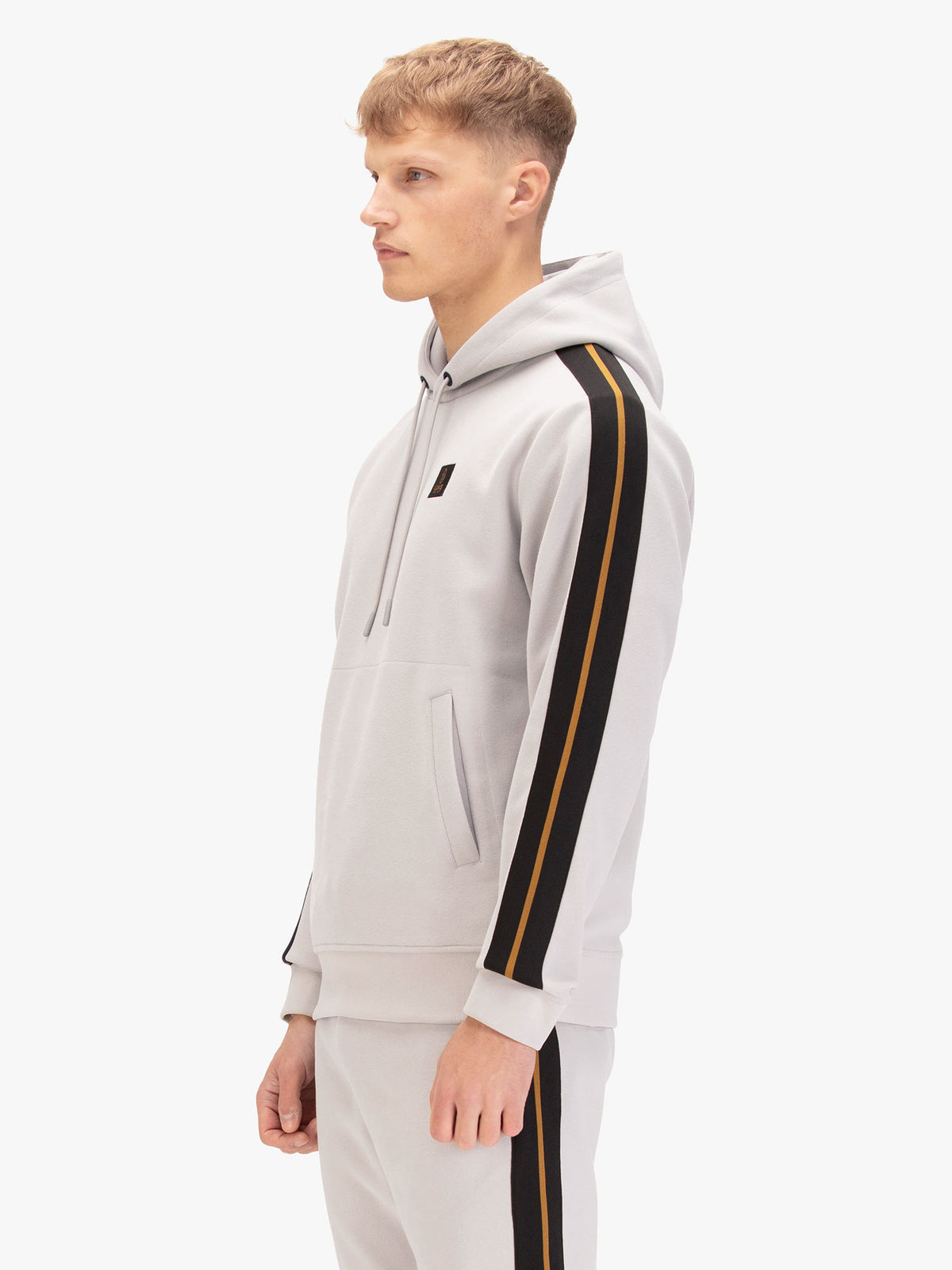 Men's grey hoodie with front pocket and drawstring hood, worn by a model, side view
