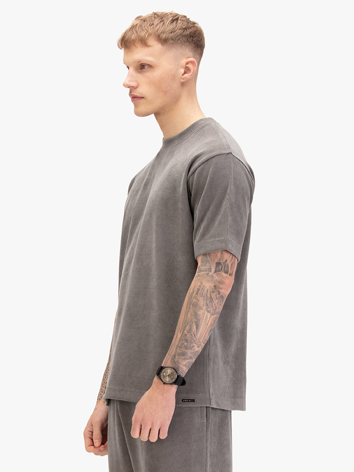 Men's relaxed-fit grey t-shirt with crew neck and short sleeves, worn by a model, side view