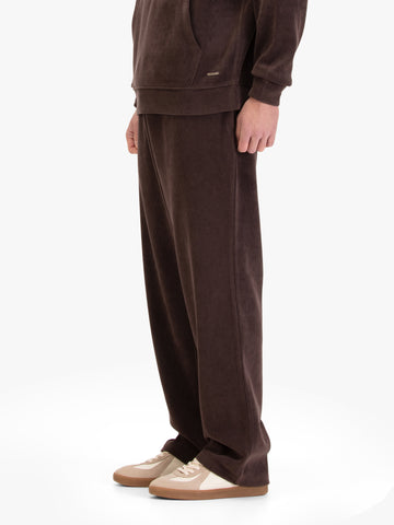 Men's straight-leg brown joggers, worn by a model, side view