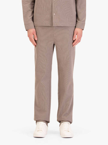 Men's straight-leg beige joggers, worn by a model, front view