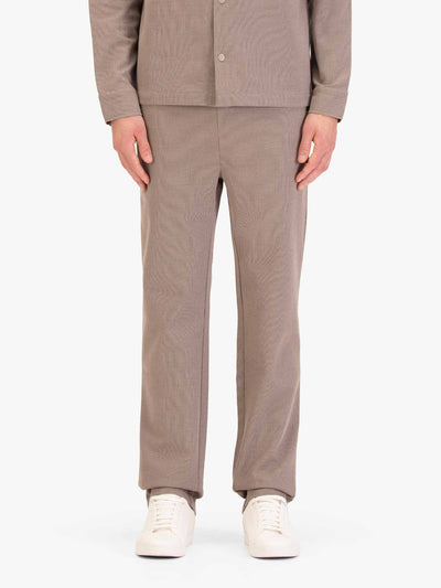 Men's straight-leg beige joggers, worn by a model, front view
