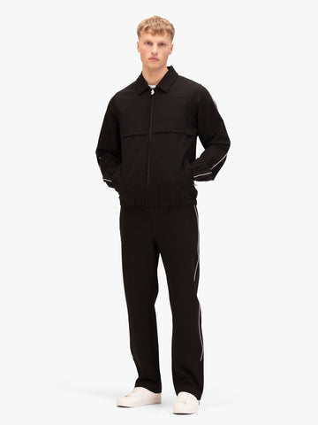 Men's black set with zip collared sweatshirt and matching joggers, worn by model.