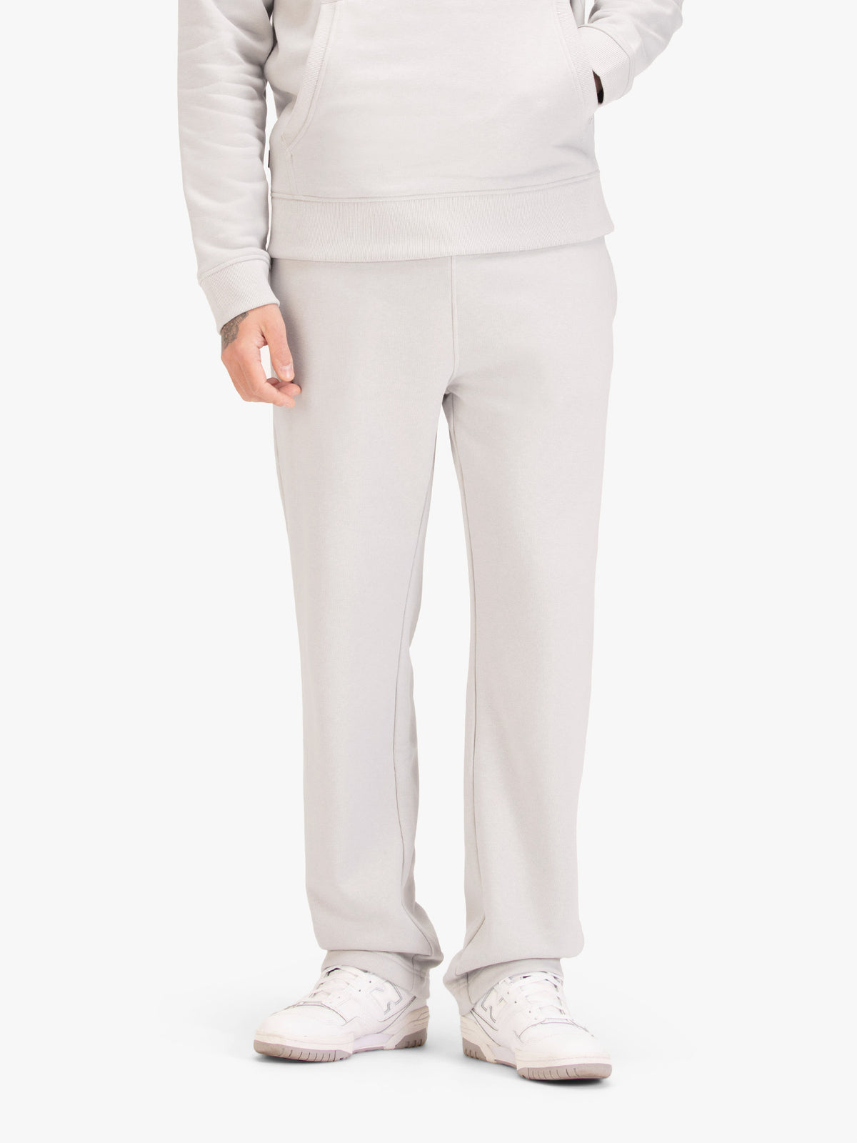 Men's wide-leg grey joggers with drawstring waistband, worn by a model, front view