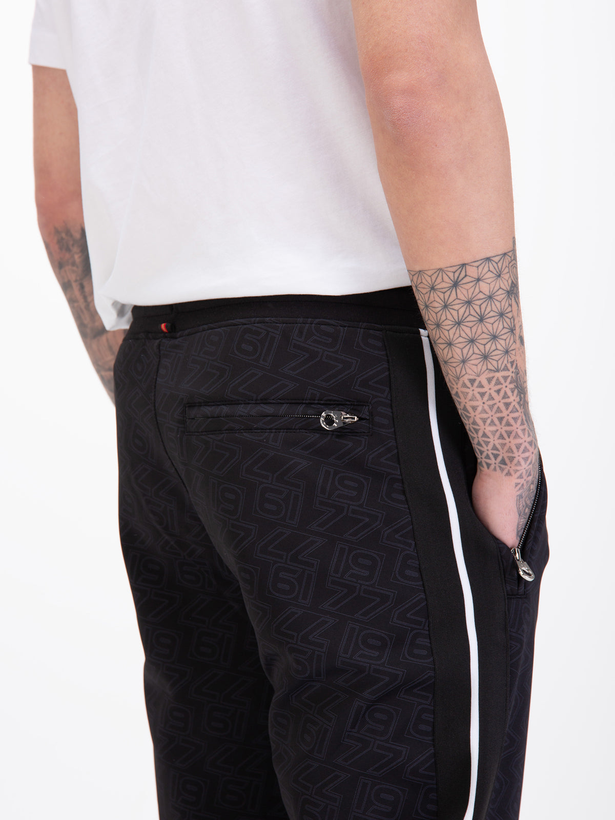 Men's black joggers with drawstring waistband, worn by a model, detail view