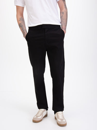 Men's straight-leg black trousers, worn by a model, detail view