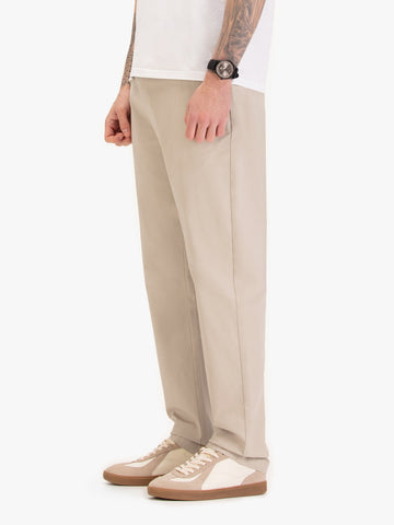 Men's straight-leg beige trousers, worn by a model, side view