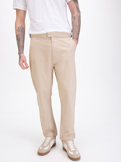 Men's straight-leg beige trousers, worn by a model, detail view