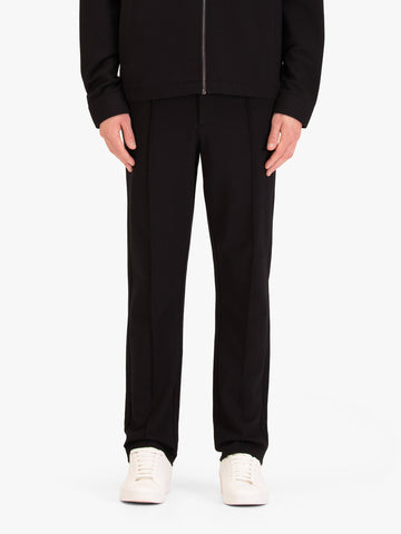Men's black trousers with drawstring waistband, worn by a model, front view