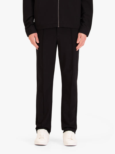 Men's black trousers with drawstring waistband, worn by a model, front view
