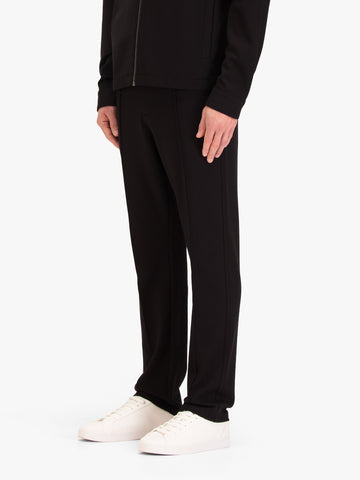Men's black trousers with drawstring waistband, worn by a model, side view