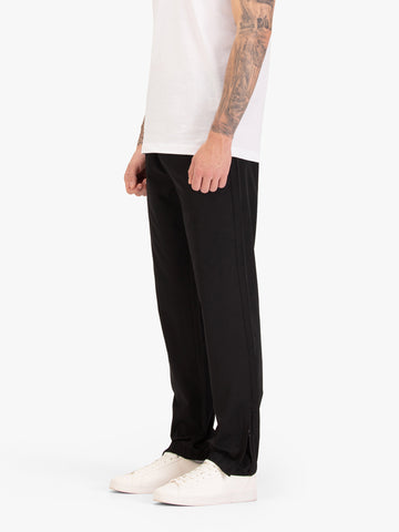 Men's black joggers with elasticated waistband, worn by a model, side view