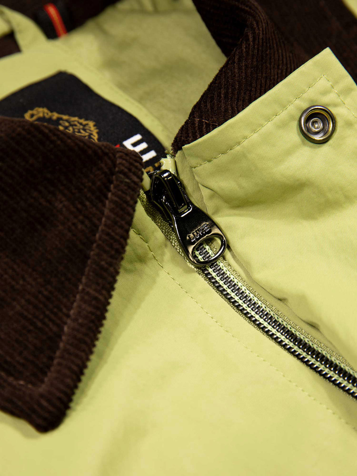 Men's green jacket with zip-up front and chest pocket, detail view