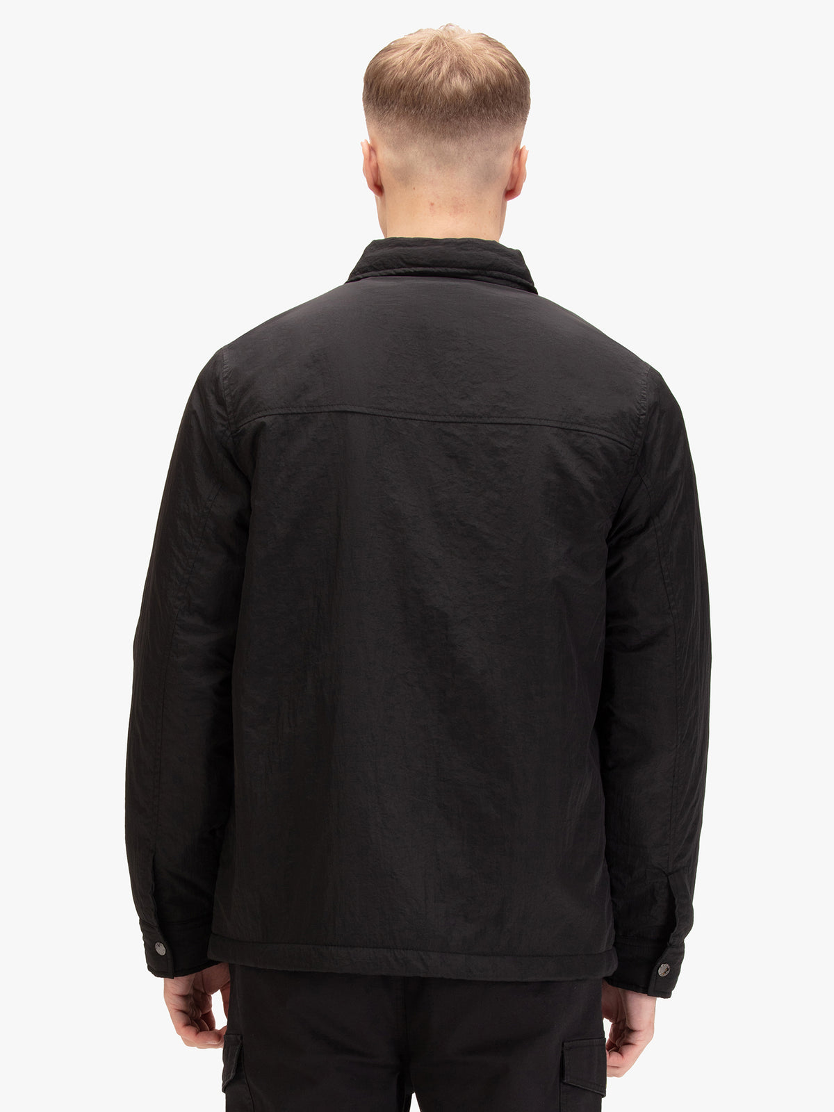 Men's black jacket with button-up front and front pocket, worn by a model, back view