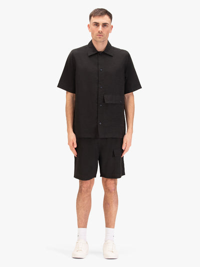 Men's black short set with short-sleeve button-up shirt and drawstring shorts, worn by a model.