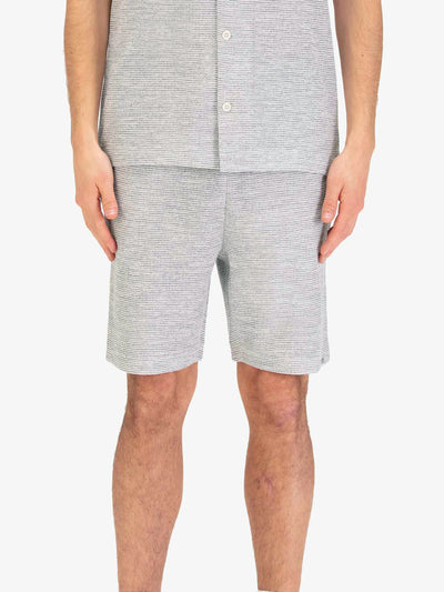 Men's grey shorts with drawstring waistband, worn by a model, front view