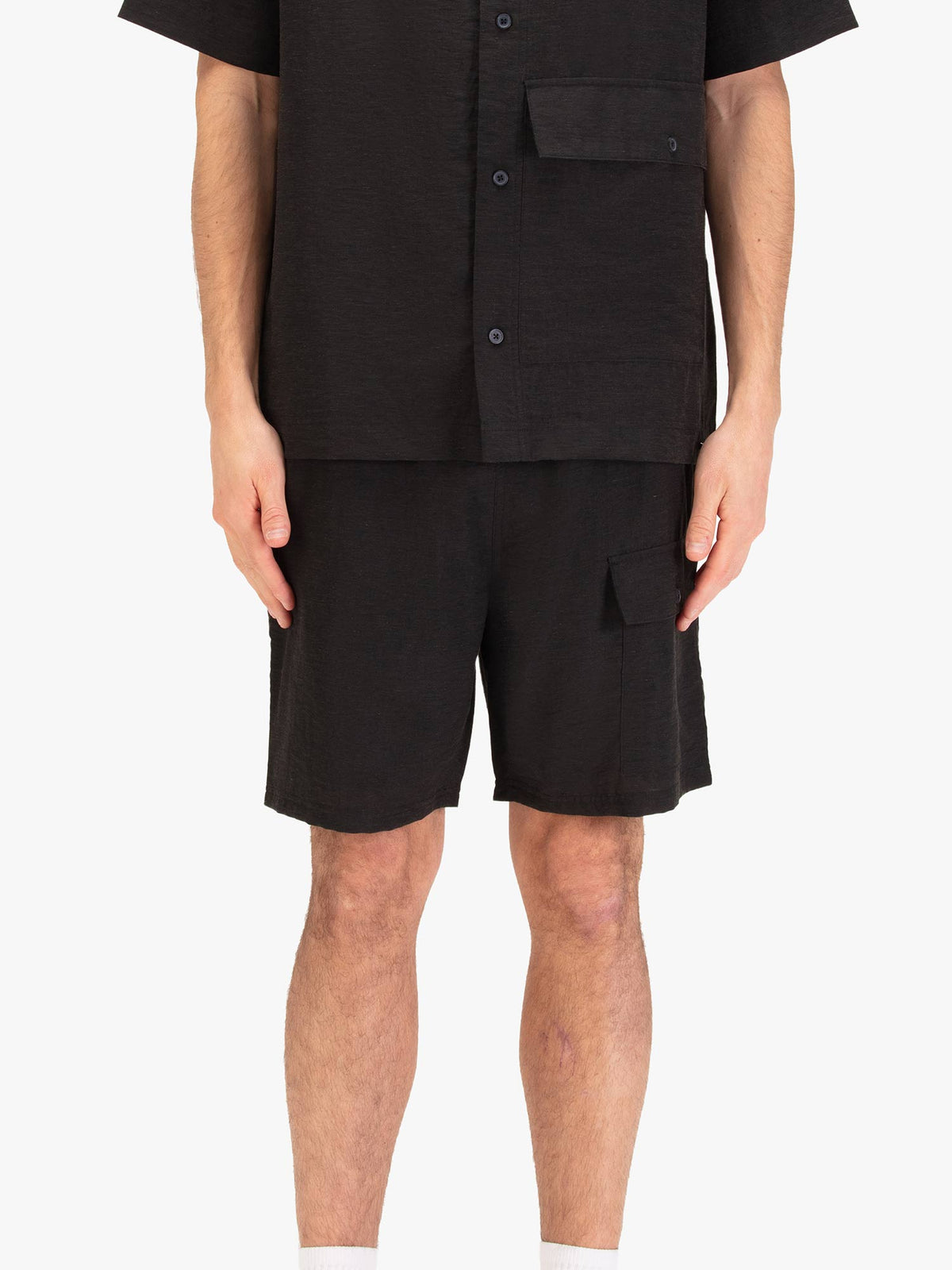 Men's black shorts with drawstring waistband and cargo pockets, worn by a model, front view