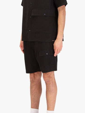 Men's black shorts with drawstring waistband and cargo pockets, worn by a model, side view