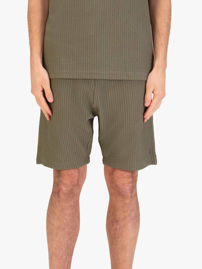 Men's green shorts with drawstring waistband, worn by a model, front view