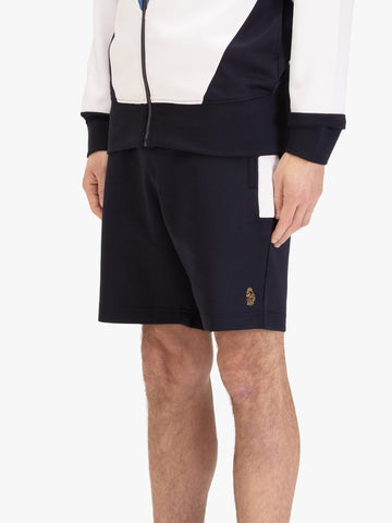 Men's navy shorts with drawstring waistband, worn by a model, side view